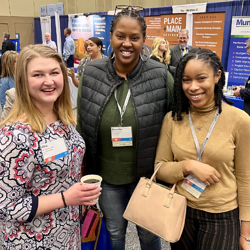 capcon-expo Members posing for a photo in front of booths at the CapCon Expo.
