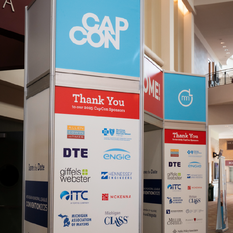 Sponsorship signage covered in sponsor logos and CapCon branding.