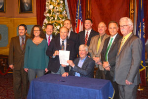 The League's Chris Hackbarth and League Member and Big Rapids Mayor Mark Warba (green tie) joined Governor Rick Snyder in signing HB 4578.