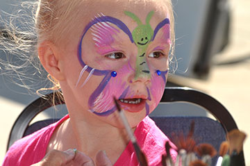 A girl is excited about getting her face painted at the Sunday Grand Blanc Farmers Market.