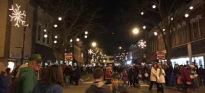 Holiday lights, decorations, and people fill downtown Allegan during the Christmas parade.
