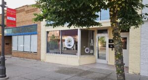 A downtown store front with a large window cling that reads, "Community Connect Center."