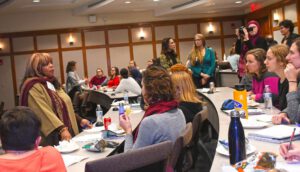 Several women converse in an auditorium