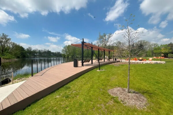 Wooden boardwalk on the river's edge with shaded seating.