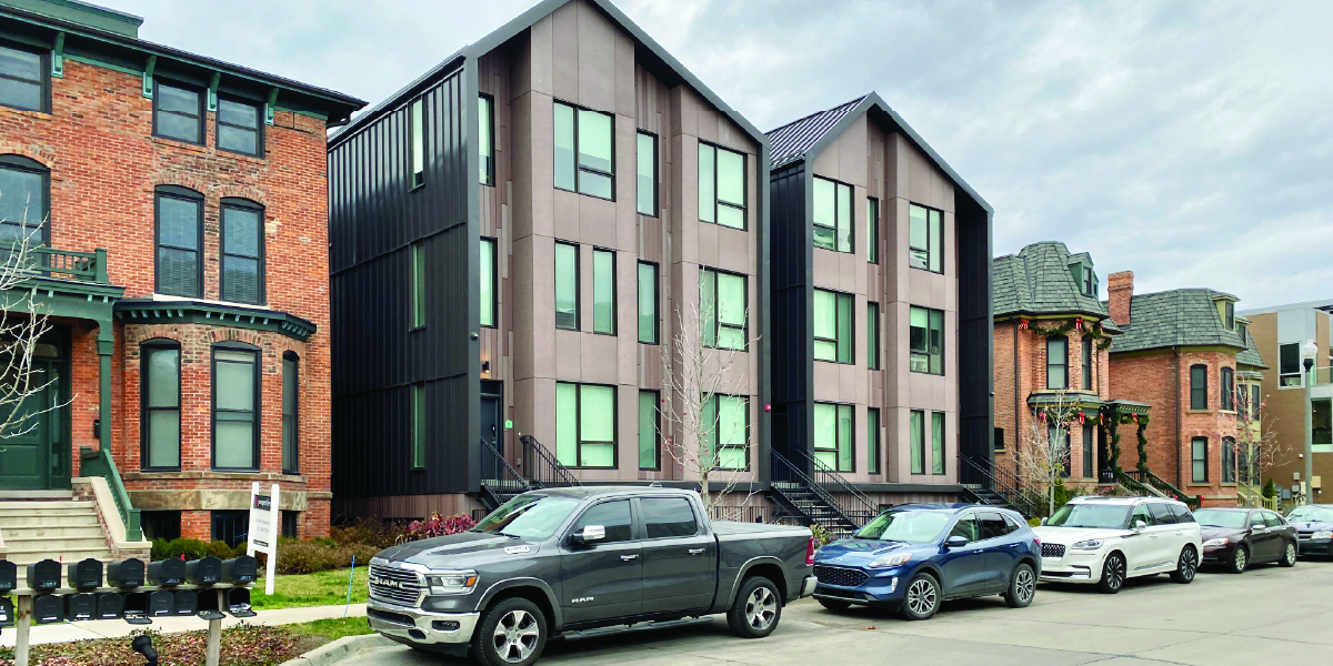brush park a modern apartment building surrounded by historic red brick houses.