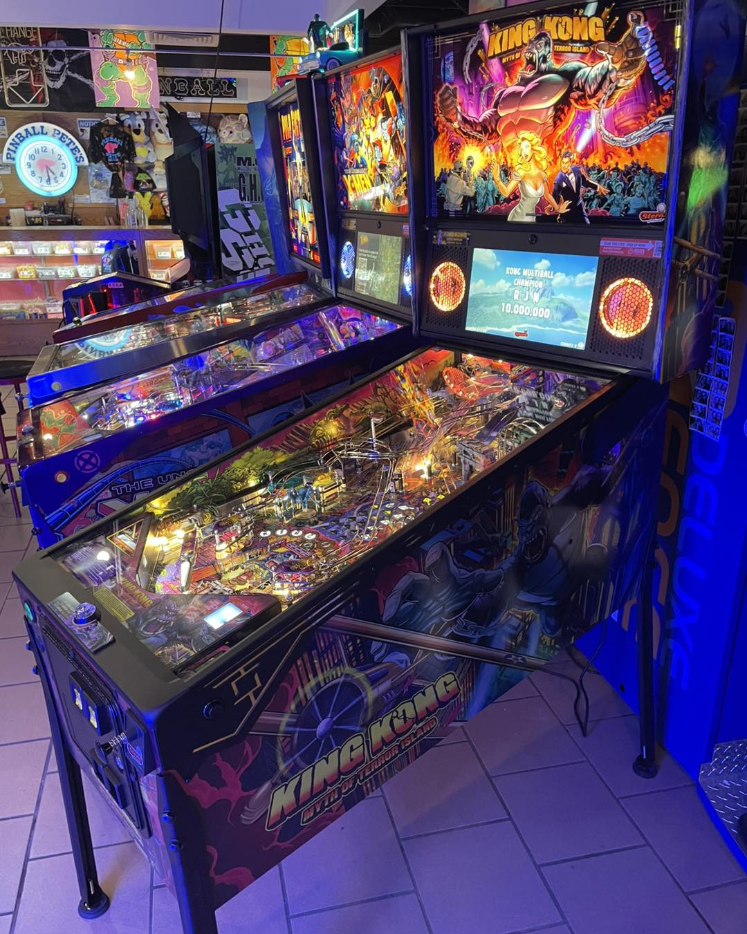 A dark room with glowing, vintage pinball machines.